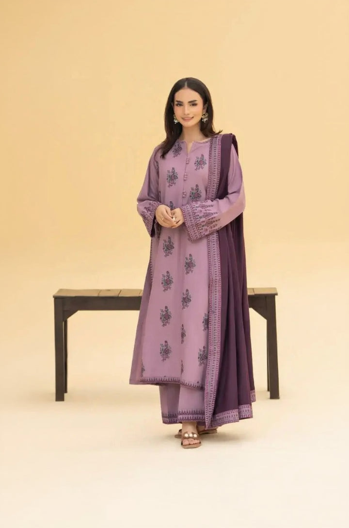 Woman wearing a purple traditional outfit with a matching dupatta on a beige background