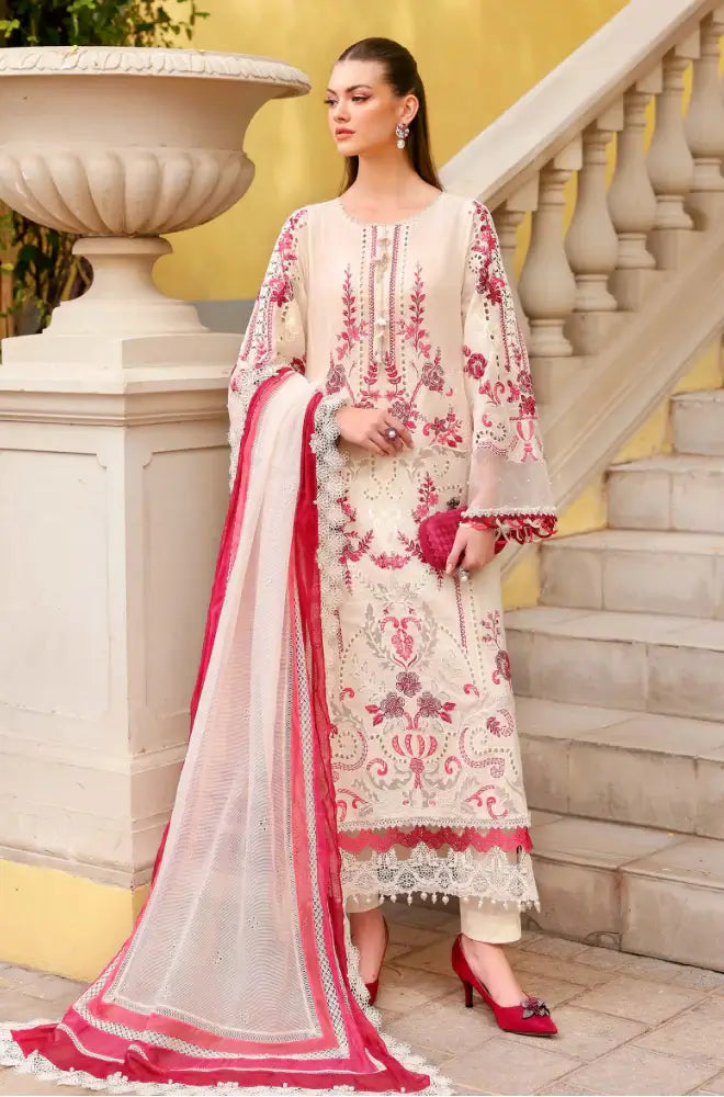 Woman in a traditional embroidered outfit with a red and white dupatta standing on steps.