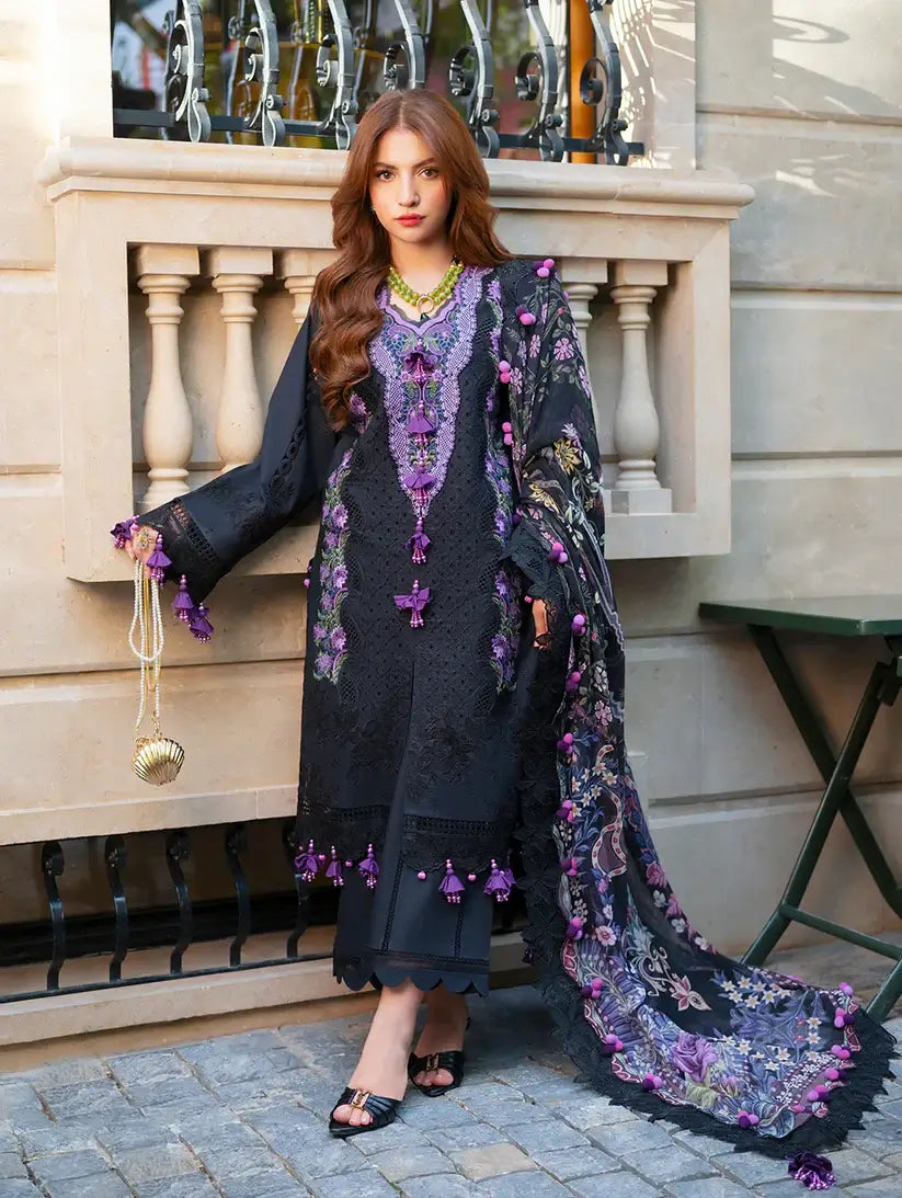 Woman in a dark blue embroidered outfit standing on a street with a building in the background.